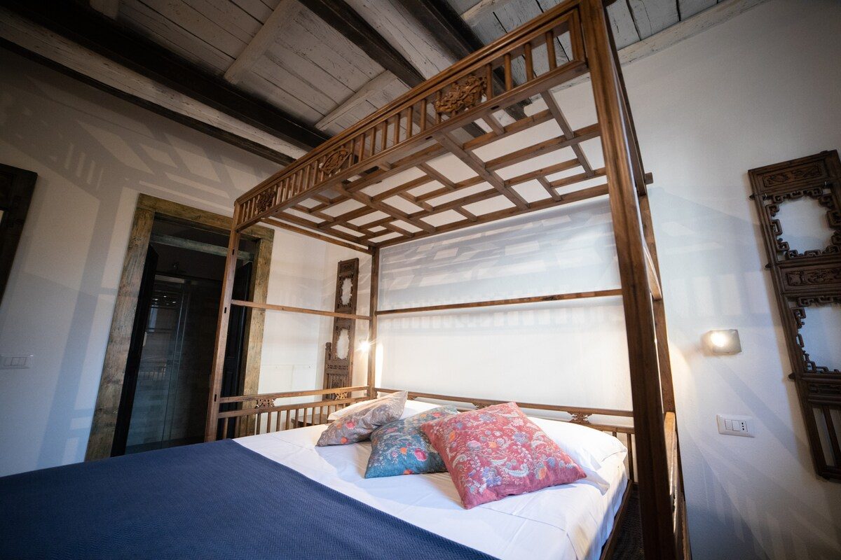 The wooden canopy bed under old beams