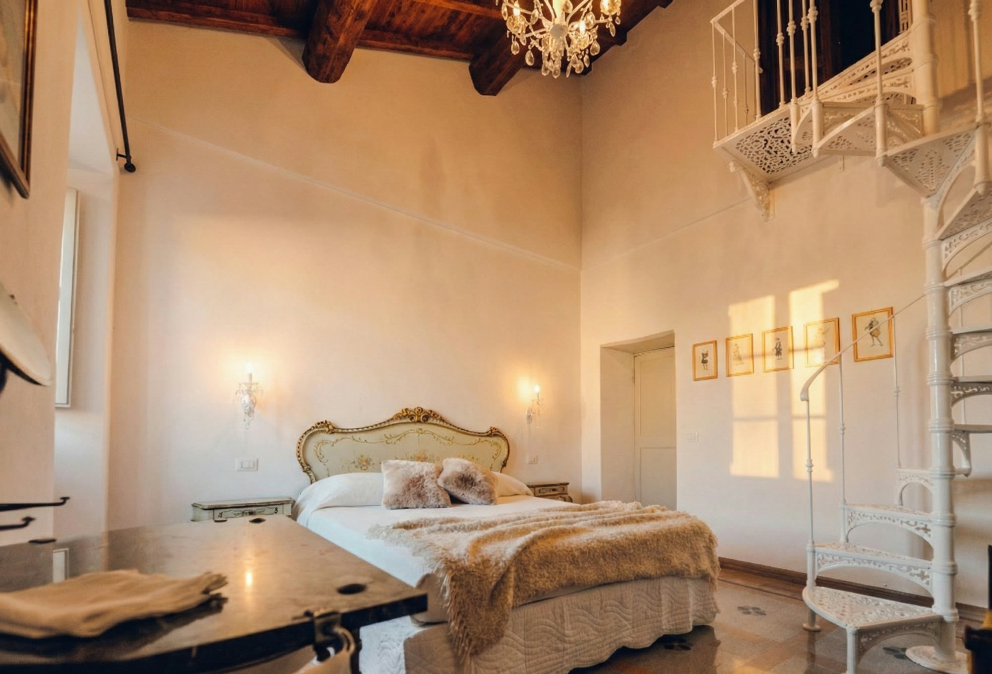 The double-height suite, its chandelier and white spiral staircase
